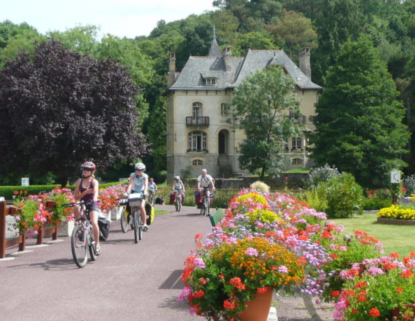 Un groupe de vélo arrive par le hallage devant la Villa Tranquillité